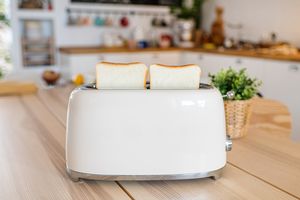 Toaster with two slices of bread on a kitchen counter