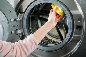 A person cleaning drum of a washing machine or dryer