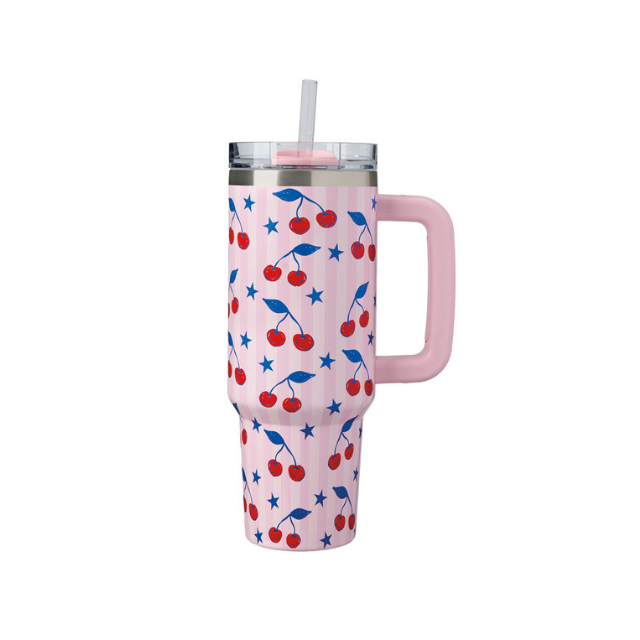 Travel tumbler with a cherry and star pattern pink handle and lid with a straw