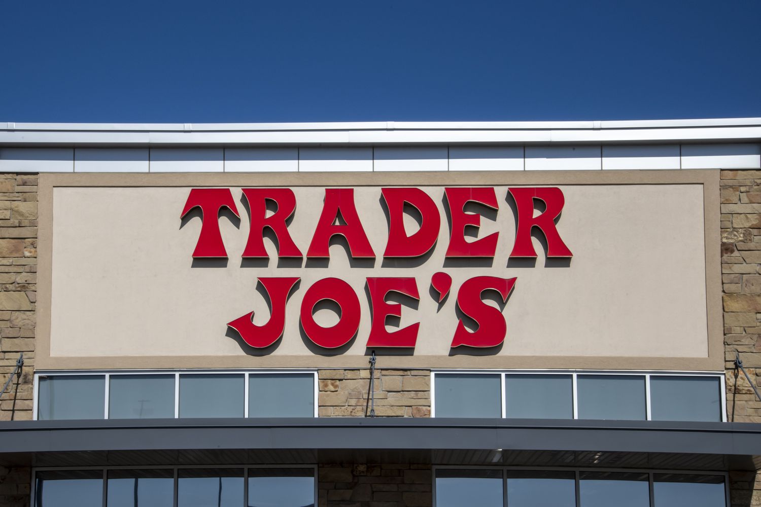 The storefront sign of Trader Joes against a clear sky