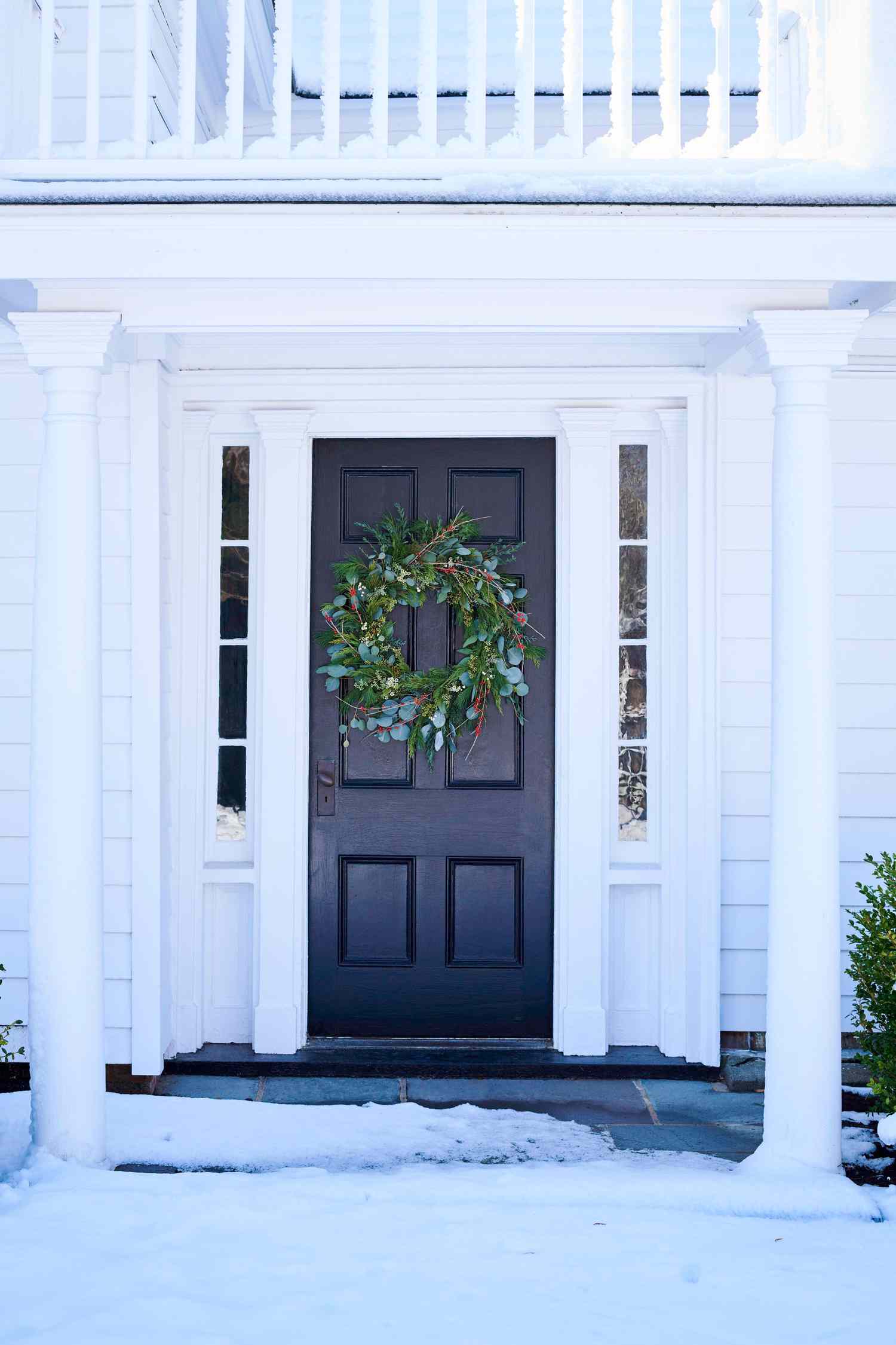 winter wreath on front door of white house