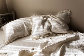 A neatly made bed with white pillows and bedding displayed in soft natural light