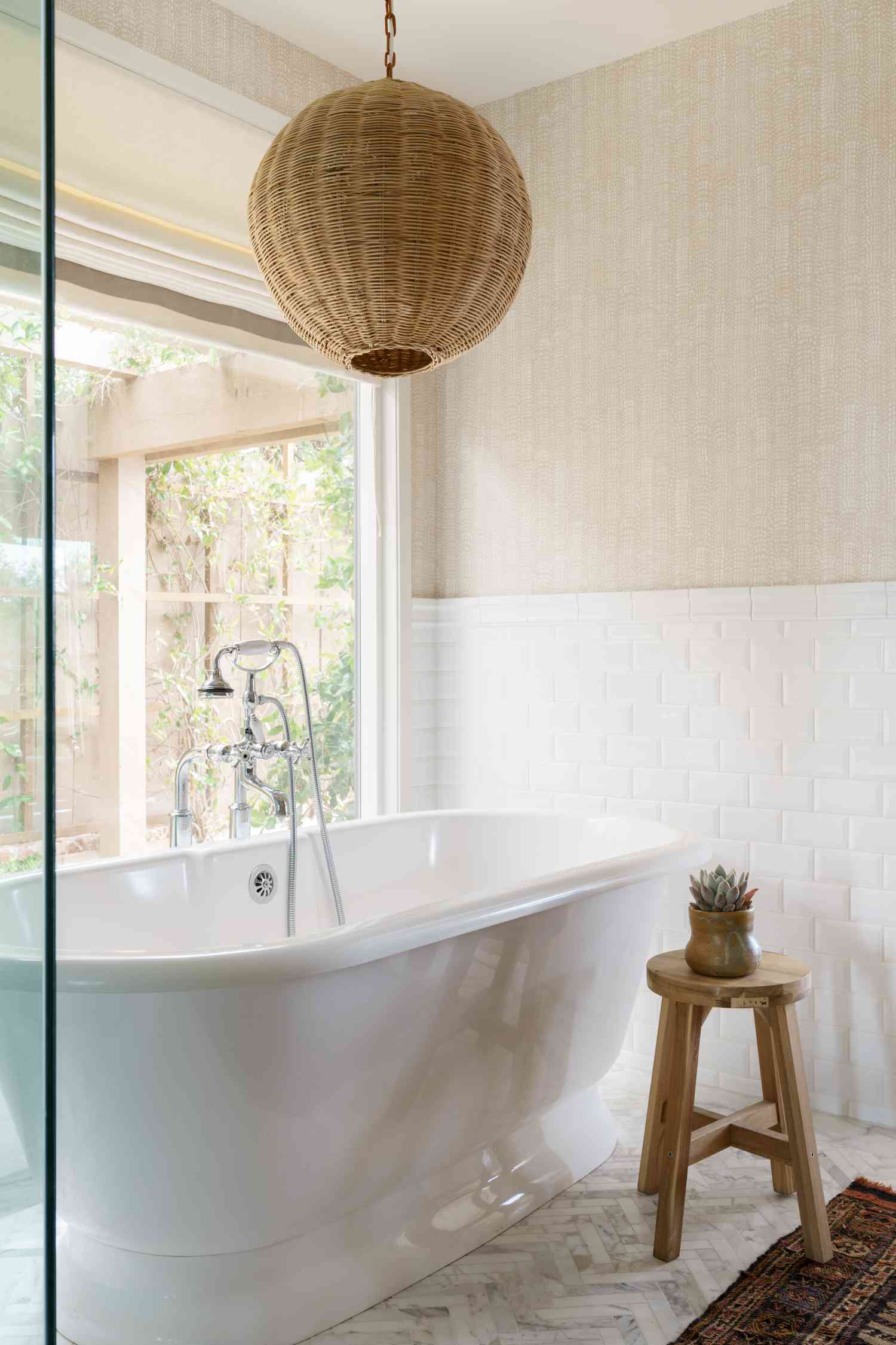 white bath tub with neutral wallpaper