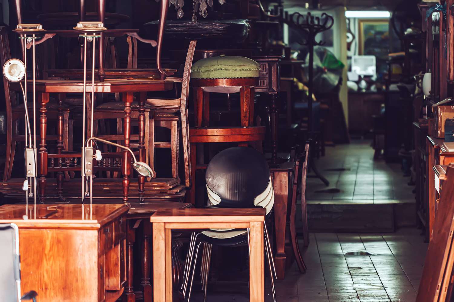 A room filled with various antique furniture pieces arranged closely together