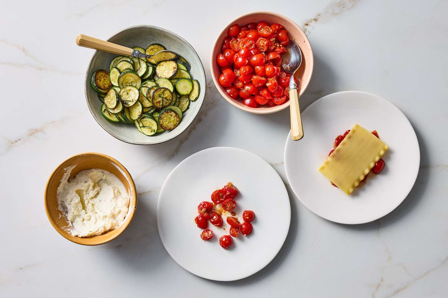 Ingredients and assembly for a nobake summer lasagna including bowls of zucchini cherry tomatoes ricotta and a layered lasagna portion