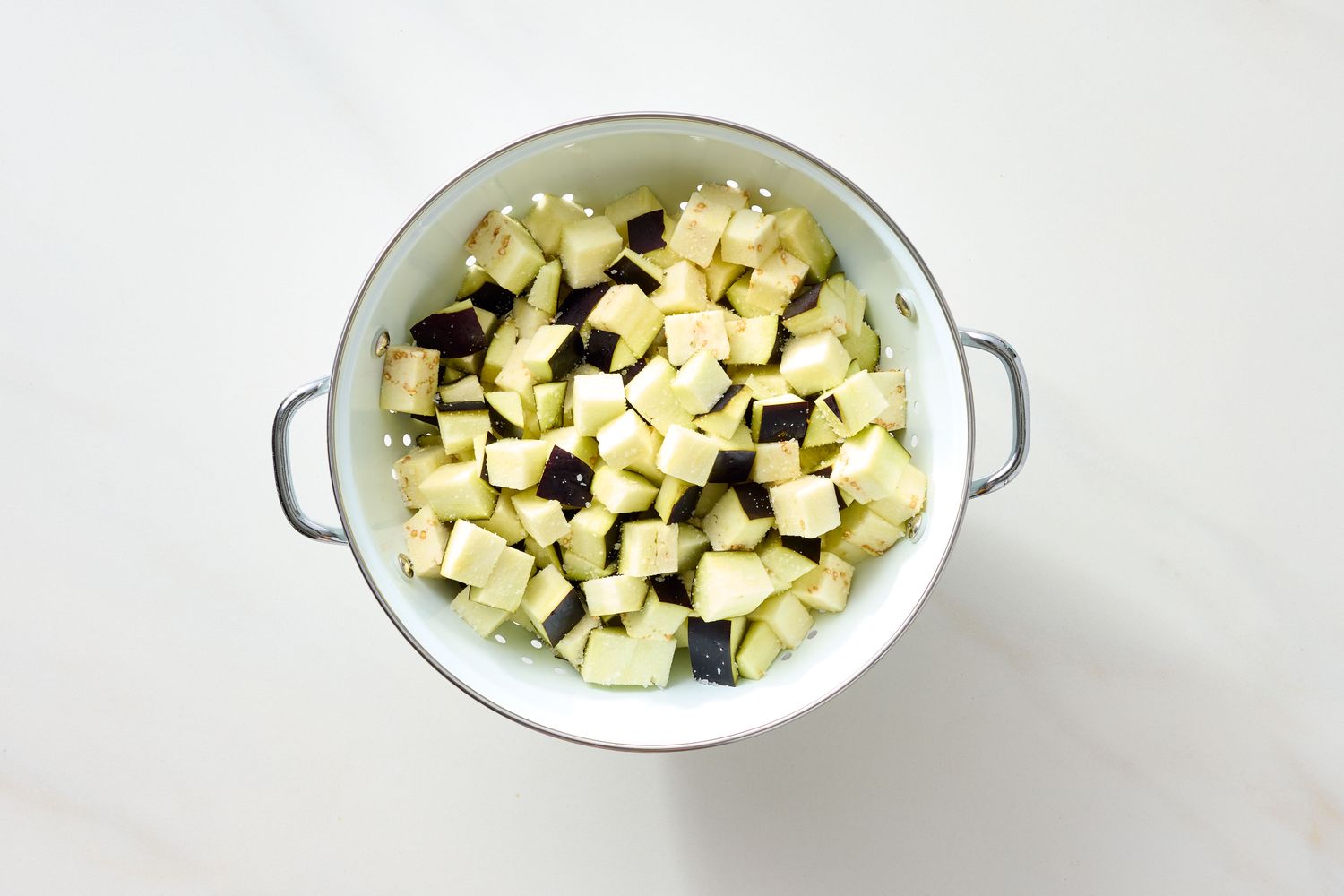 Diced eggplant pieces in a colander