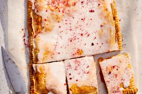 Iced pastry with knife on parchment