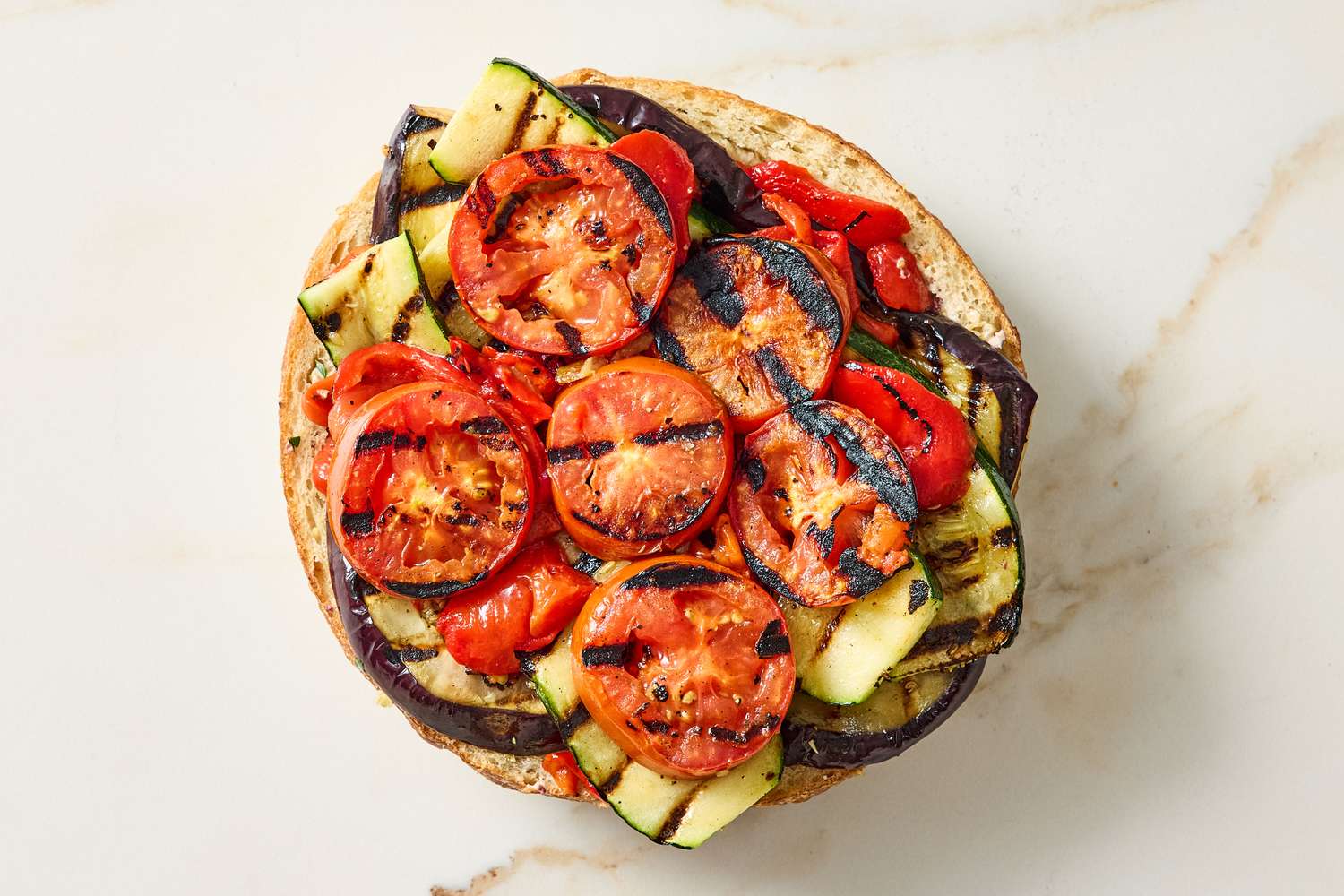 Grilled vegatables on flat round bread arranged in layers