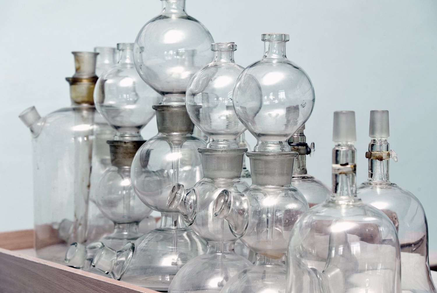 Multiple glass laboratory flasks and apparatuses arranged on a surface