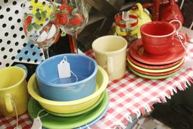 A collection of colorful dishes and glassware displayed on a gingham tablecloth