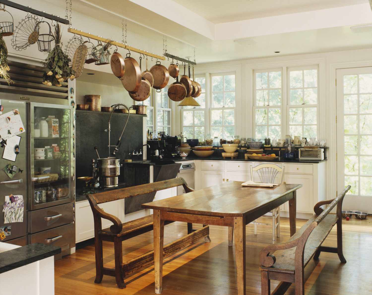 Rustic kitchen with hanging pots wooden table and benches
