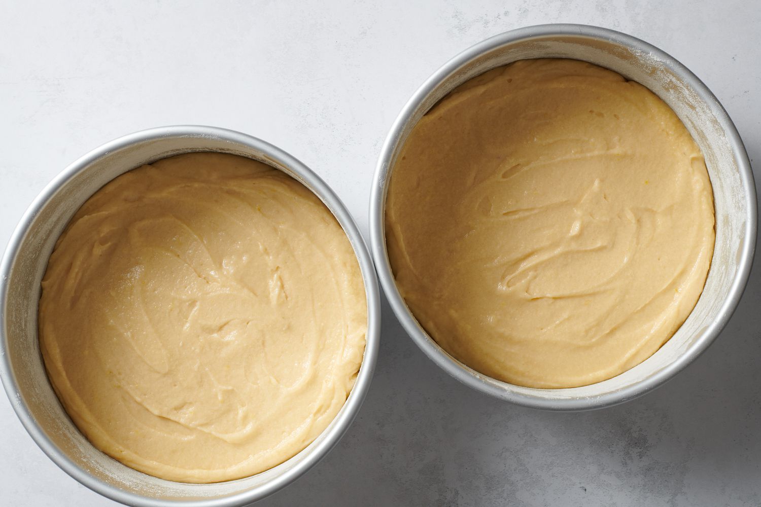 cake batter in two round cake pans