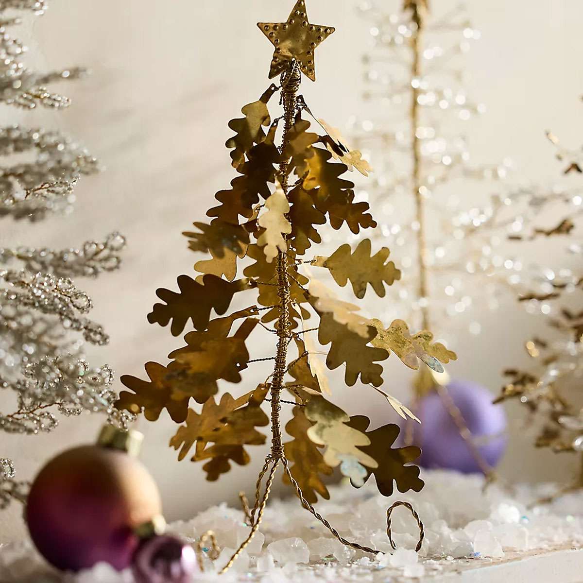 Stylized metallic tree decoration with ornaments and a star topper