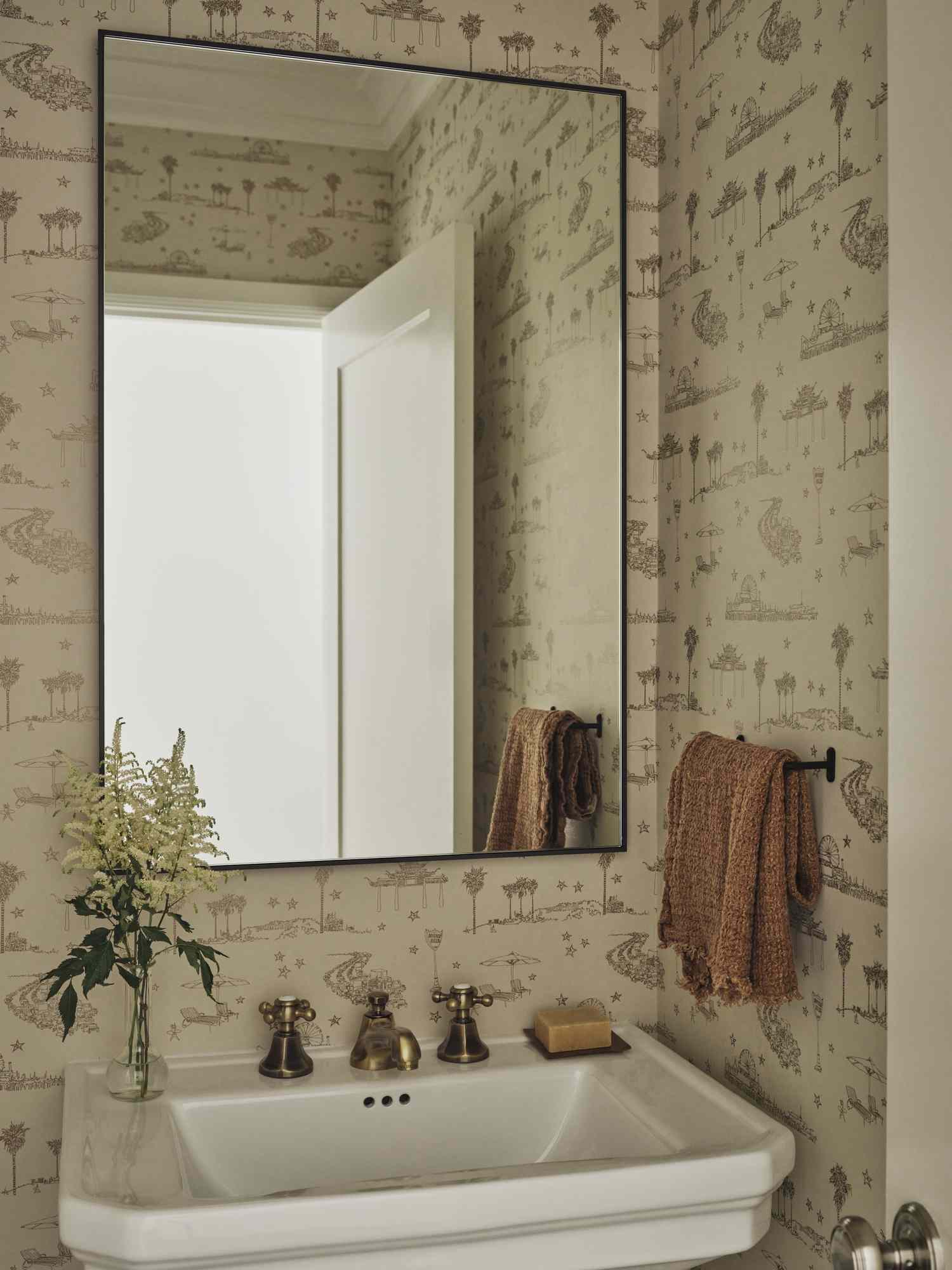 powder room with traditional porcelain sink and simple black framed mirror
