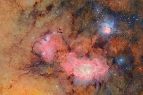 A view of the Trifid Nebula and surrounding region in space, showing detailed interstellar gas and light emissions