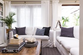 A cozy living room with white furniture and decorative pillows