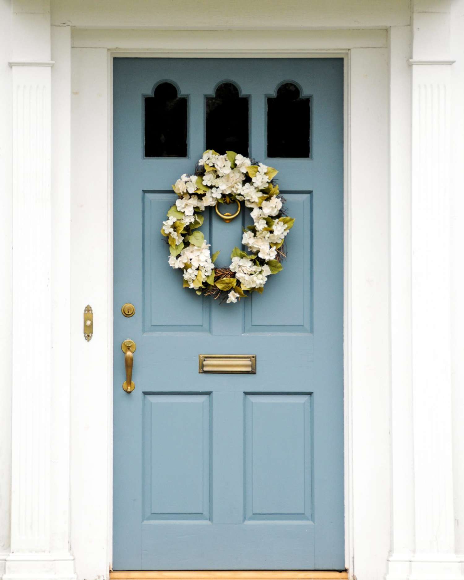 Blue door with wreath on stone home.