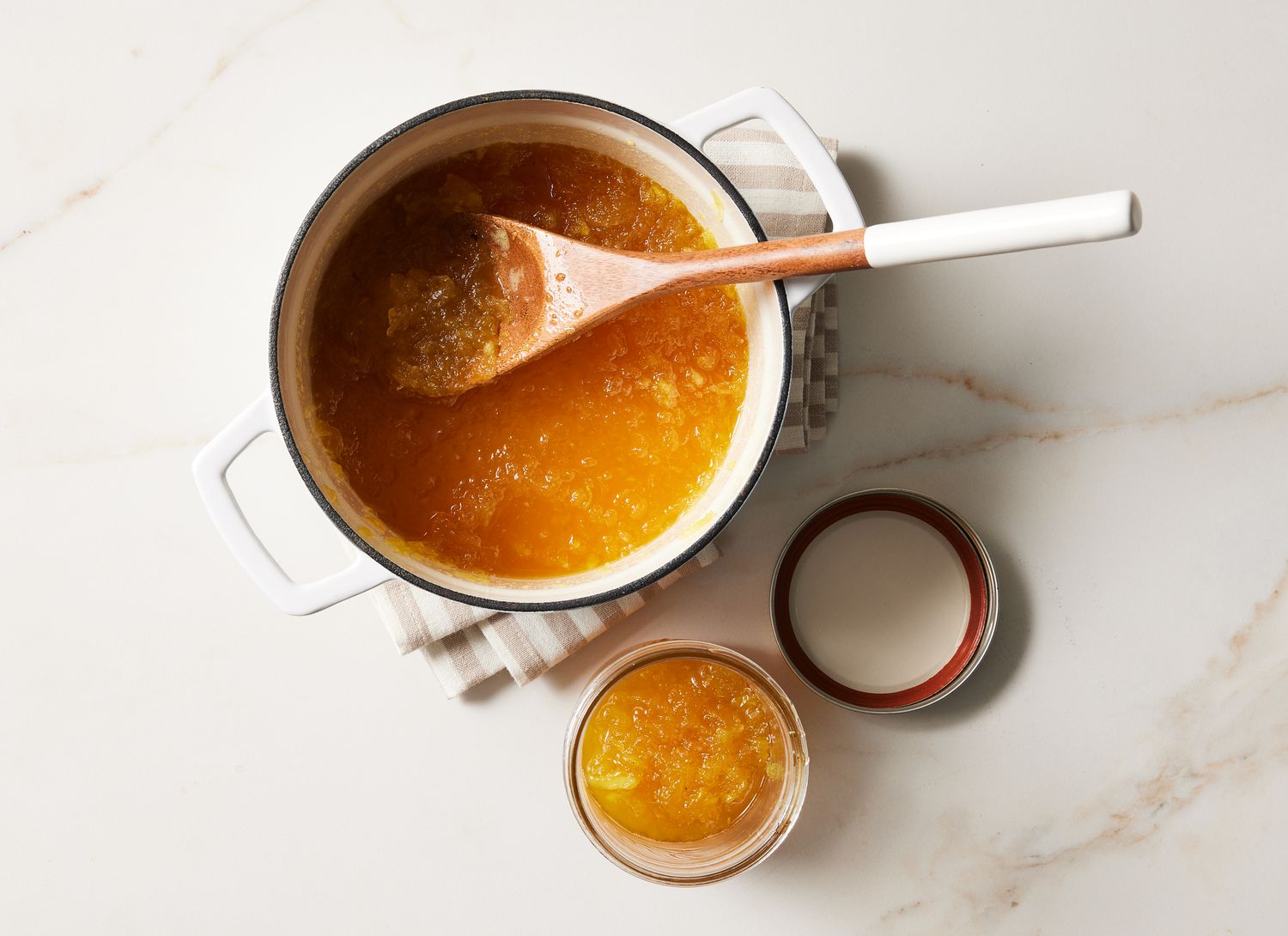 white pot with pineapple jam in it and a jar next to the pot