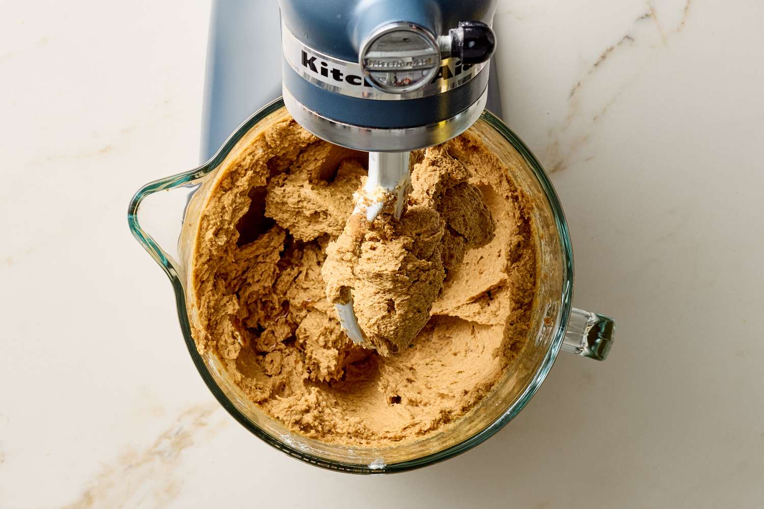 A stand mixer with thick dough in the bowl