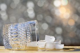 An overturned glass and ice cubes on a surface