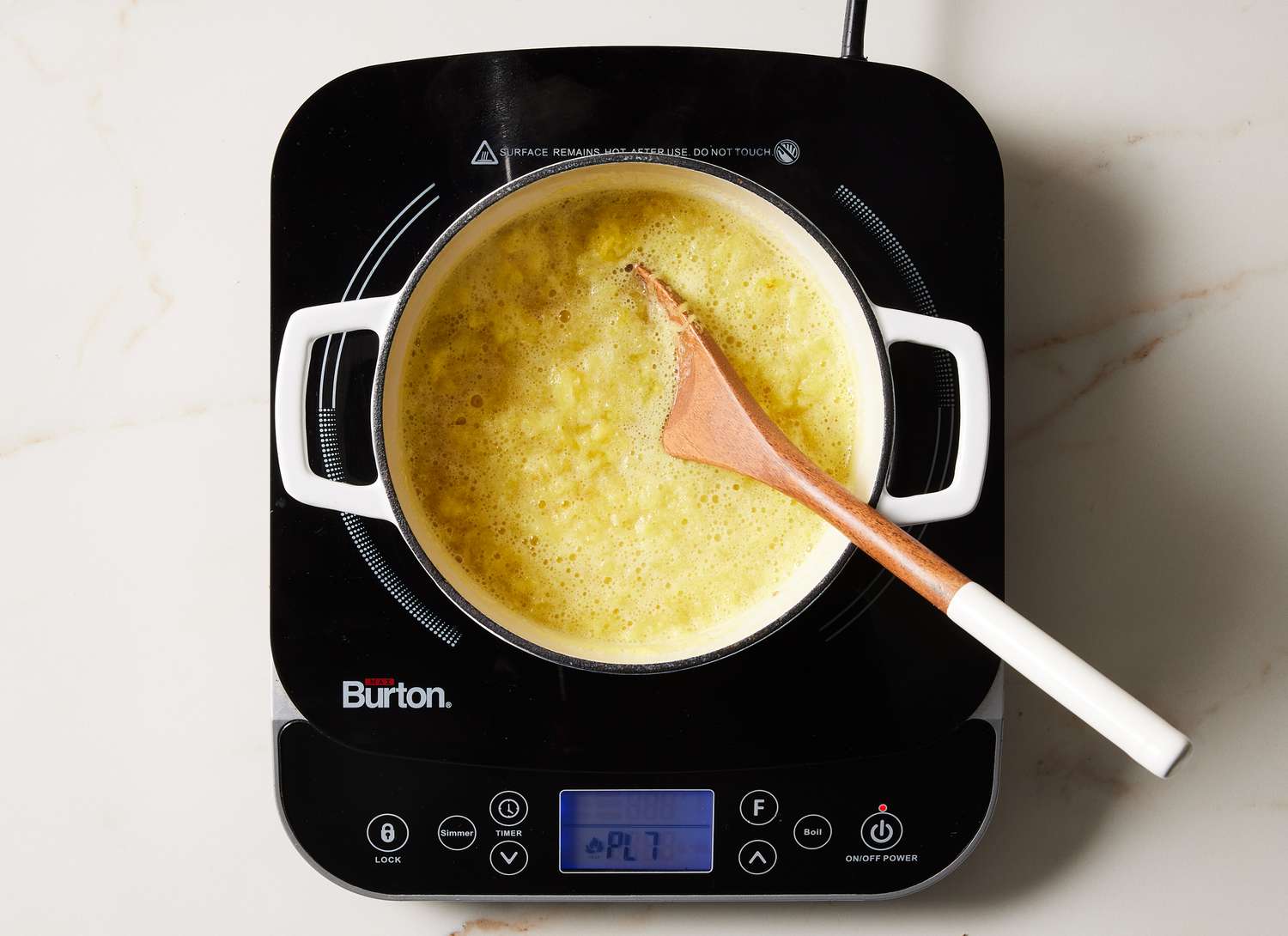pineapple in a white pot on a cooktop