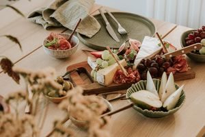 Assorted food items including cheese, fruit, and meat on a table setting