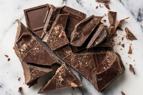 Chunks of broken chocolate on a marble surface