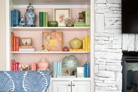 white shelving with pink wallpaper behind