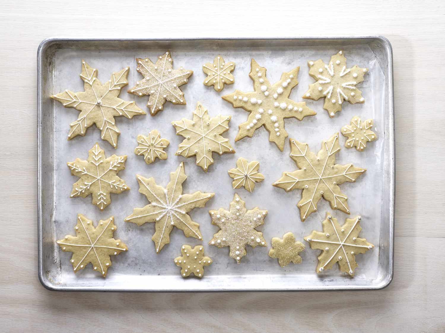 Tray of snowflakeshaped cookies with various patterns of decoration