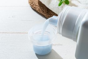 Pouring liquid laundry detergent into a measuring cap
