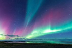 Northern lights shining over a beach at night