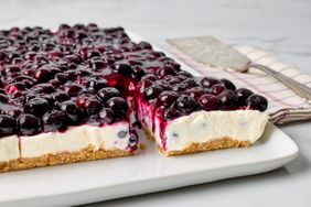 Blueberry cheesecake with a cut piece on a serving platter