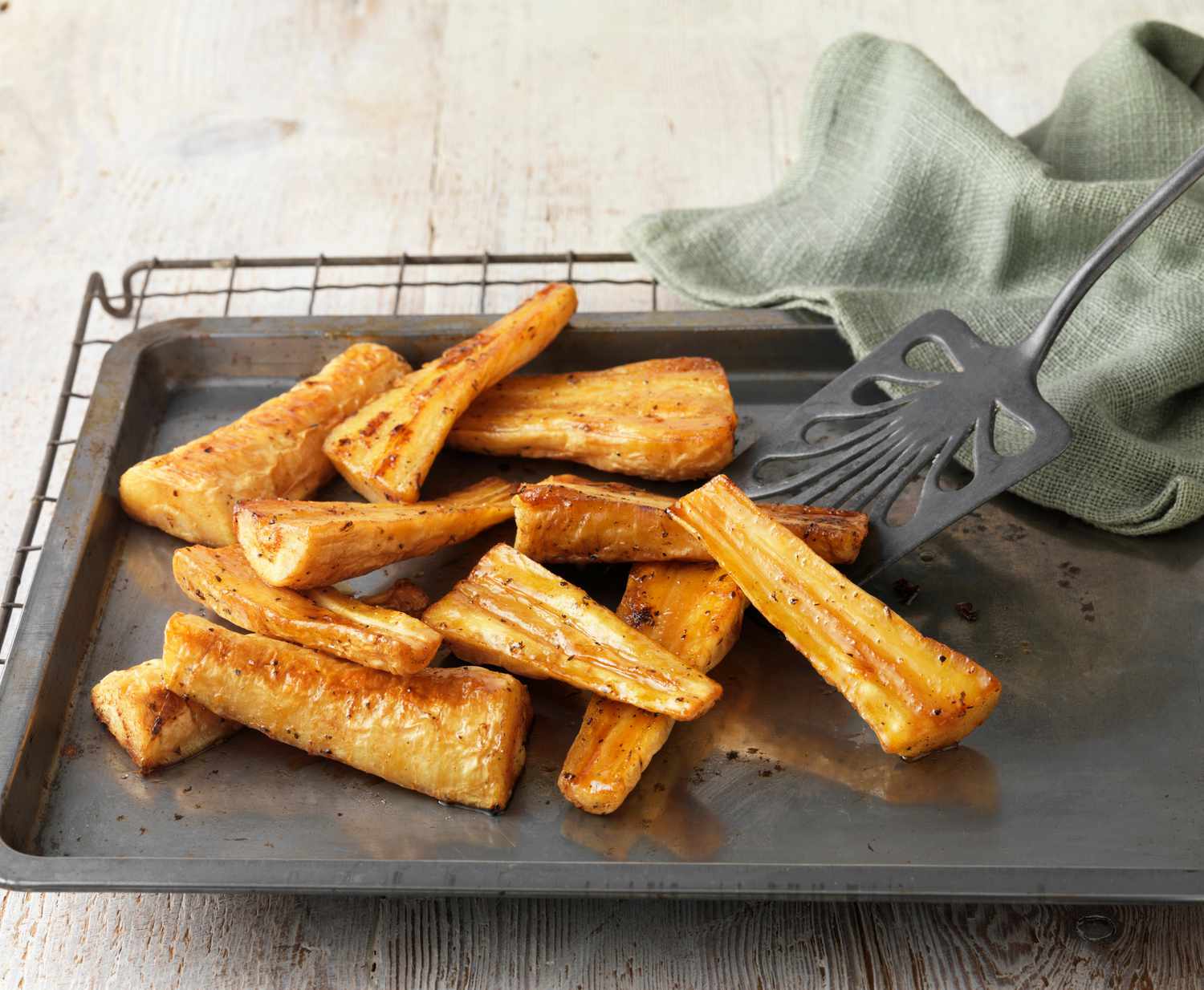 Honey roast parsnips on baking tray with green cloth