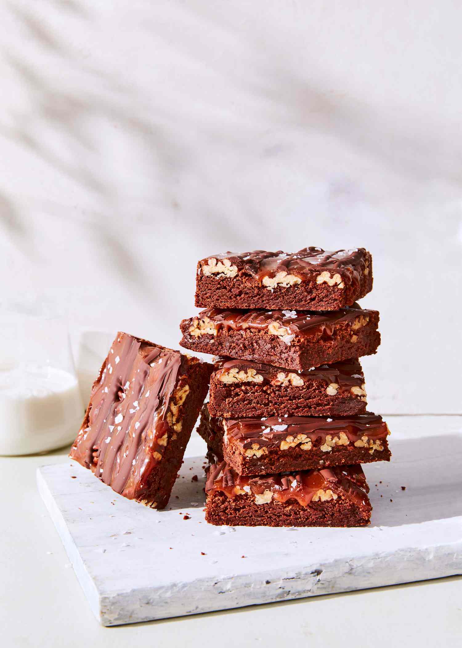 fudgy turtle brownies stacked on cutting board