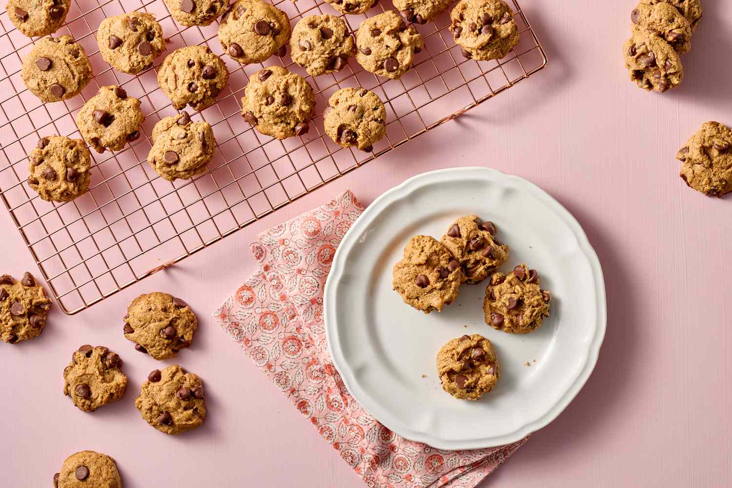Chocolate chip cookies on a cooling rack and on a plate with a napkin