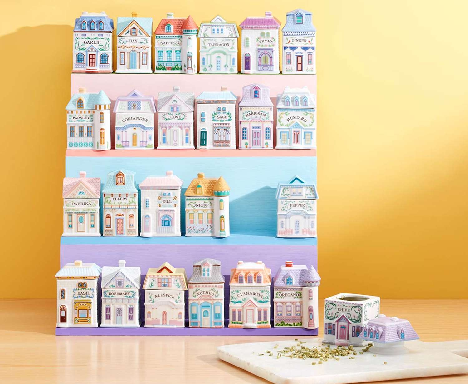 Collection of spice containers shaped like small town buildings, arranged on shelves