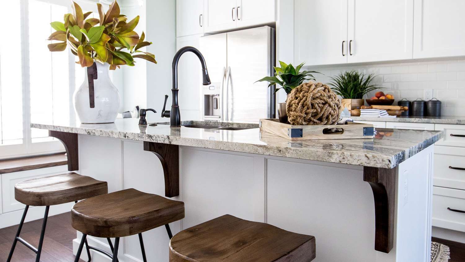 A white kitchen with wood stools