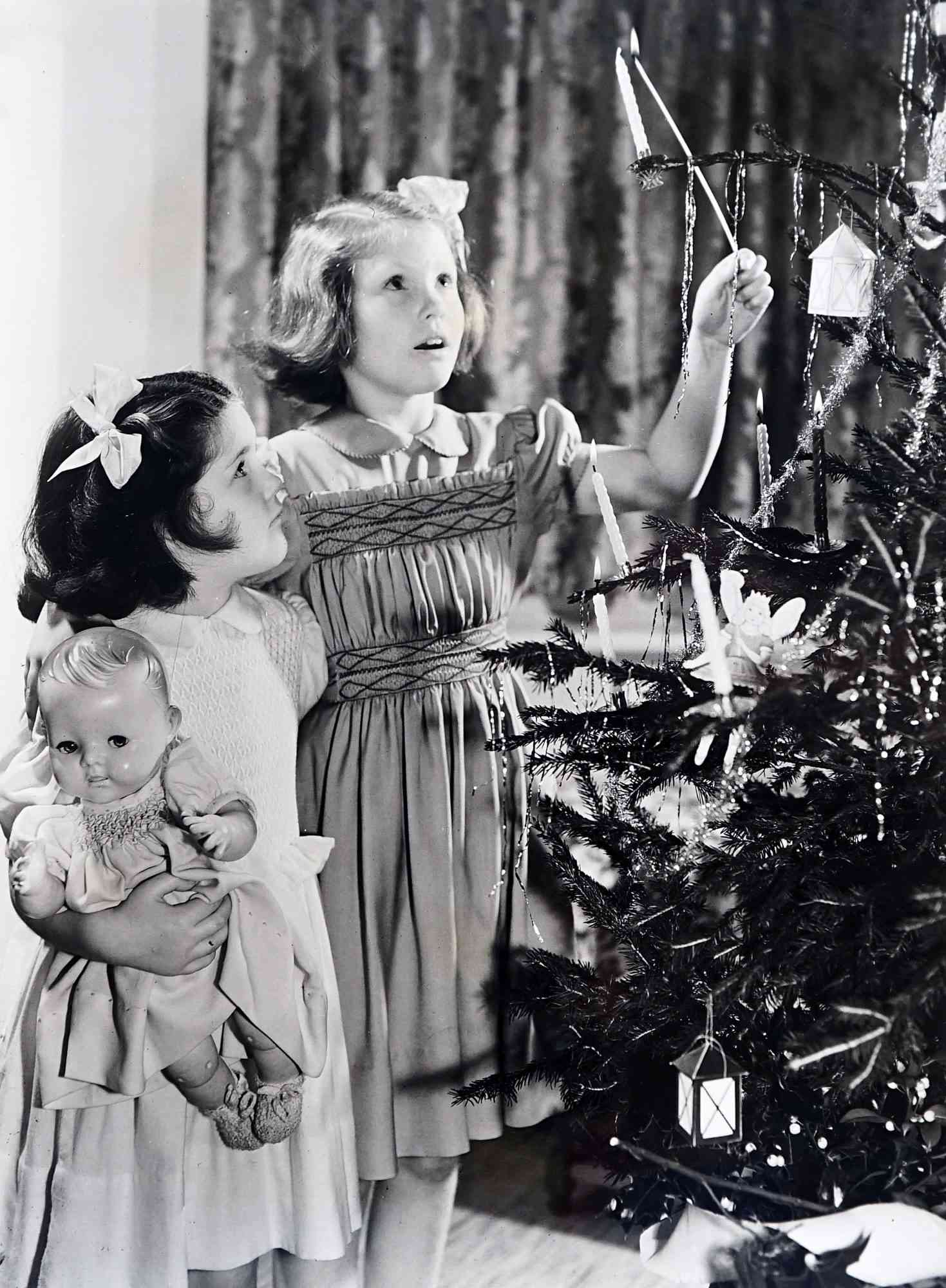 Photograph of children lighting the candles on the Christmas tree