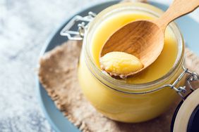 overhead view of a jar of ghee on blue plate