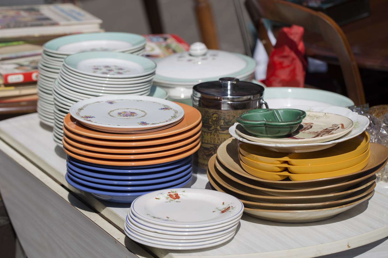 Stacks of various plates and kitchenware on a table