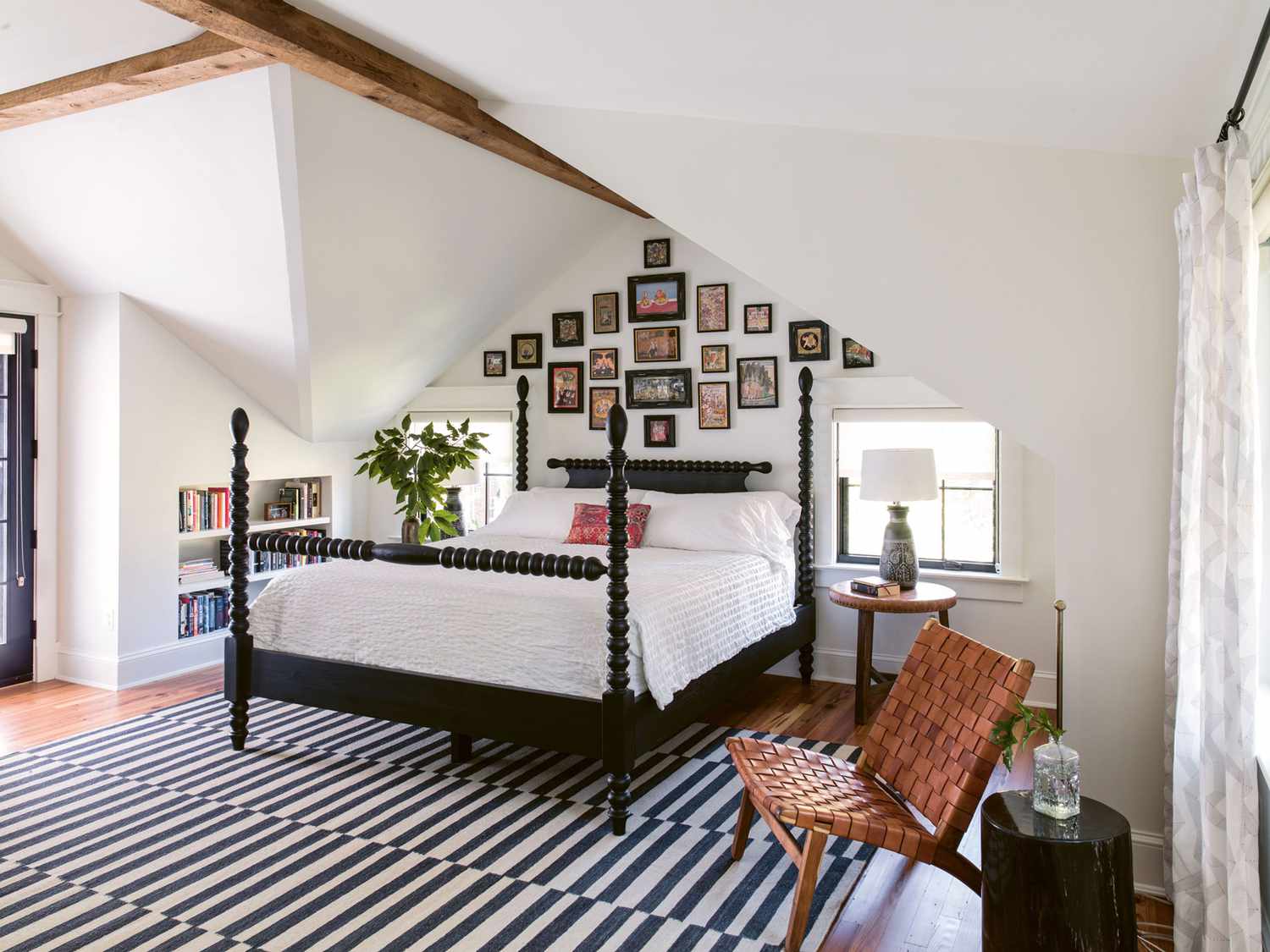 master bedroom with black spool bed and sloped ceilings