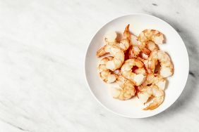 Raw shrimp on a plate on white background