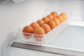 A row of eggs in a transparent container inside a refrigerator
