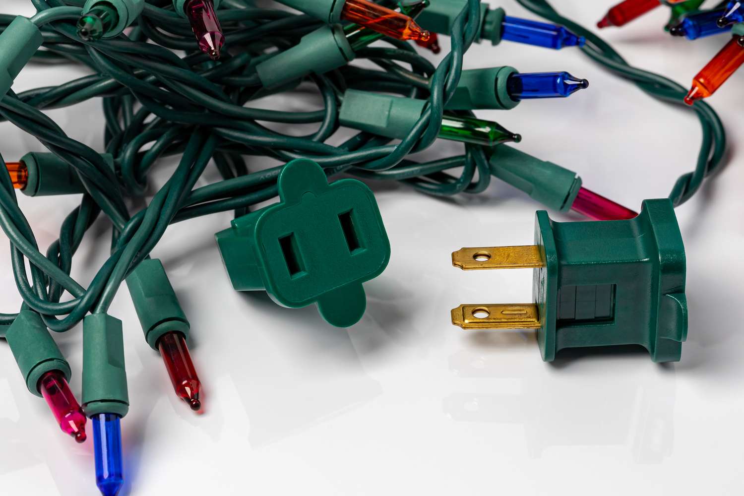 Electric Christmas light strands with a green plug and various colored bulbs