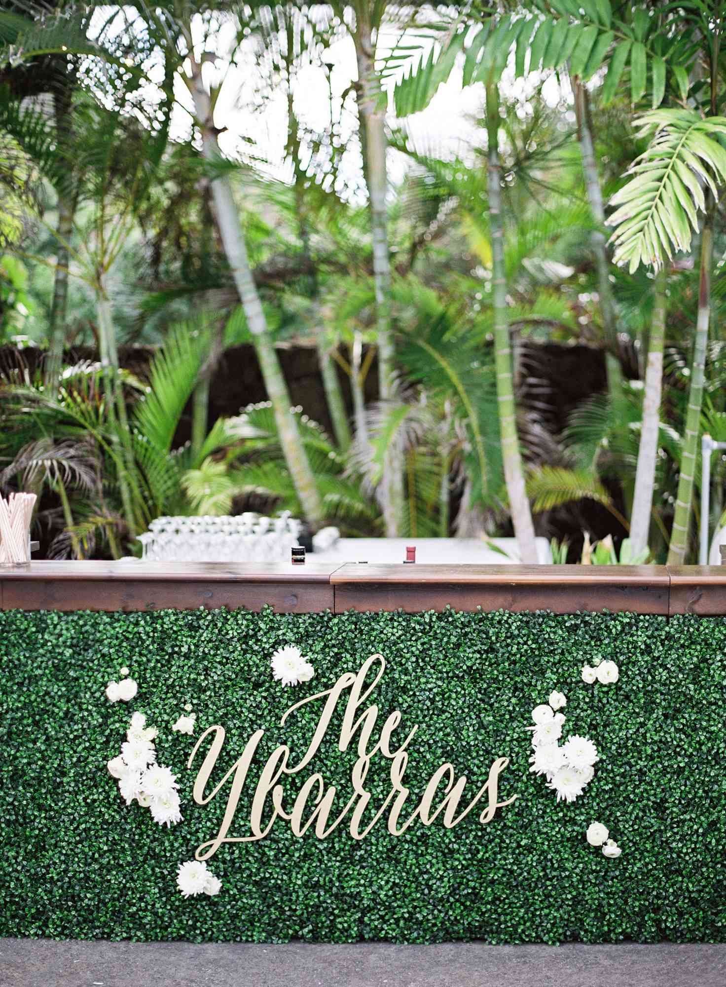 wedding decor name lettering on bar green palm trees