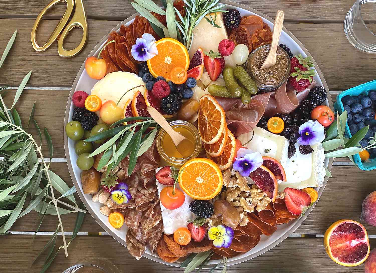 overhead view of a round charcuterie board on wooden surface