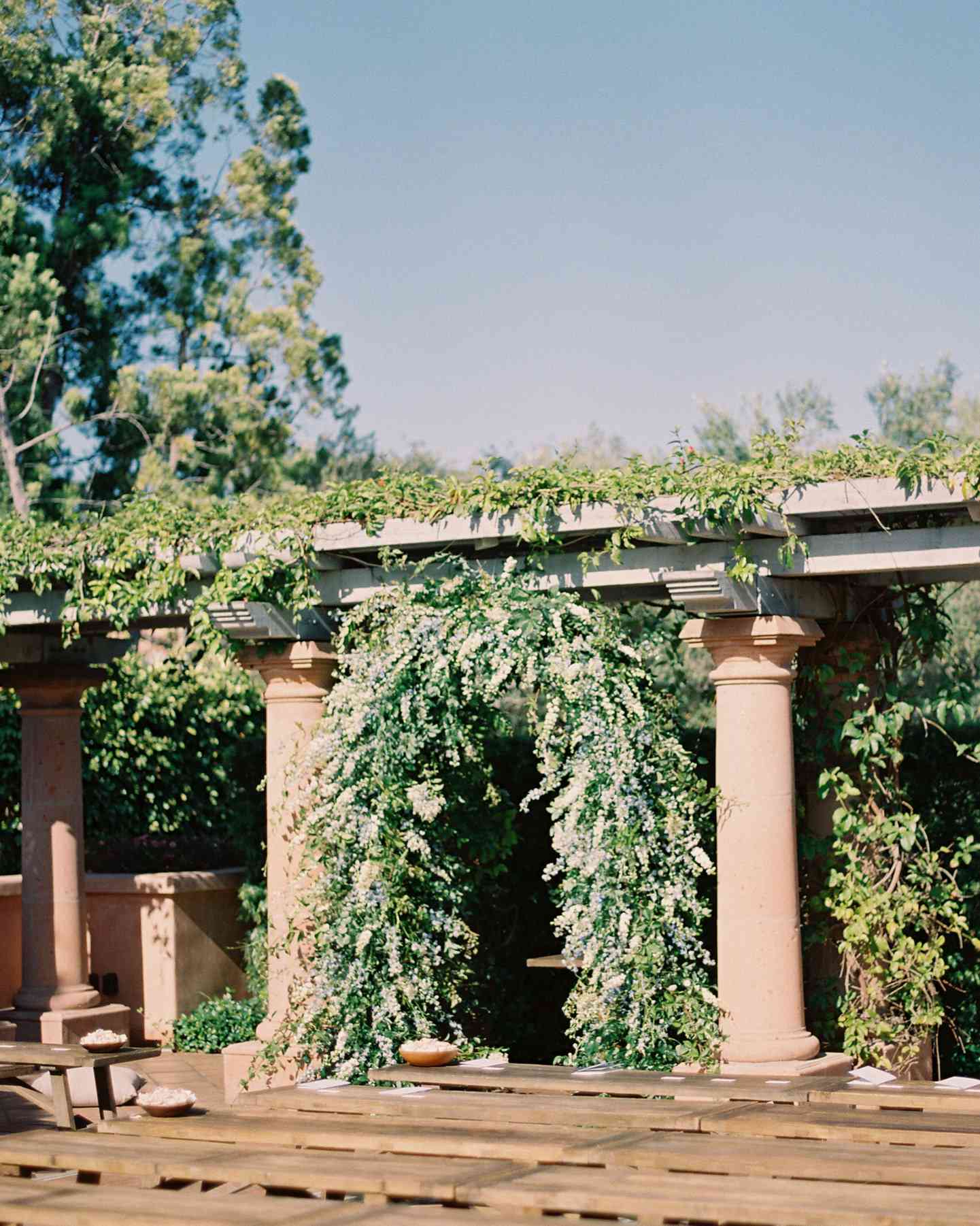 outdoor ceremony space full floral greenery arch