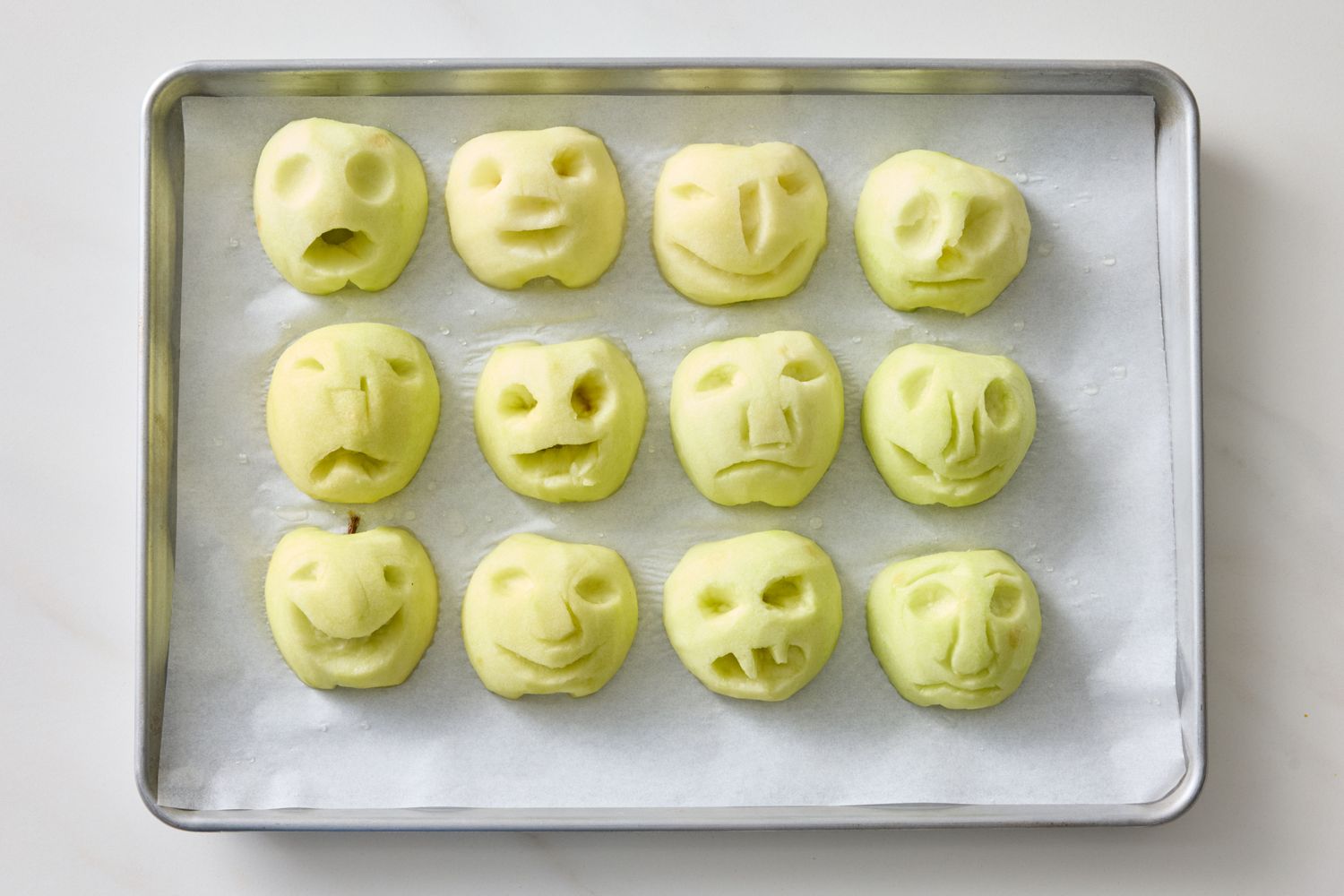 Tray with carved apple pieces resembling humanlike faces