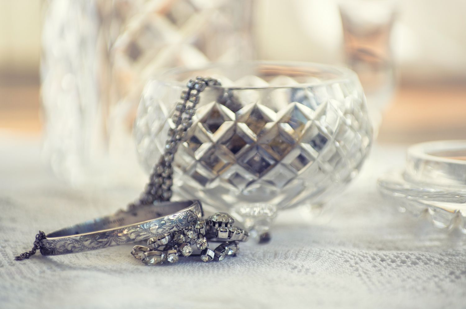 Crystal bowl with a bracelet and jewelry on a lace surface