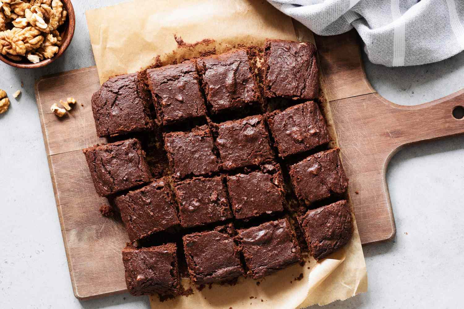 Chocolate brownie squares with walnuts on cutting board